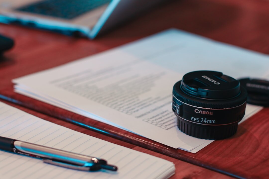 Journalist working at desk with camera equipment and notes